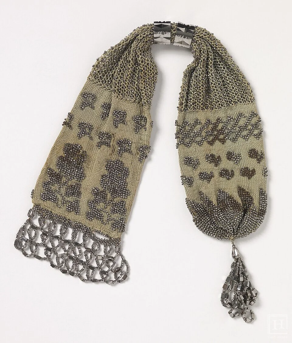 1850〜1890年頃にアメリカで作られたと推定されるMiser’s purse。グレーのシルクをニッティング技法で編み、スチールビーズと金属リングを加えた / Wikimedia
